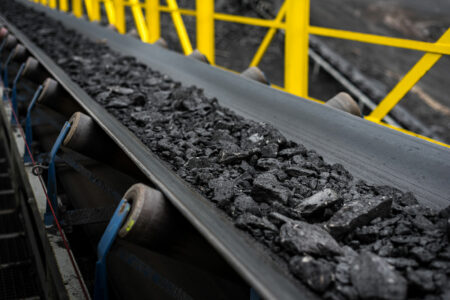 Lumps of hard coal on a conveyor belt on the way to sampling