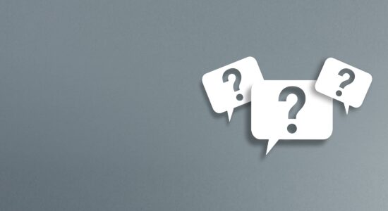 FAQ - Frequently Asked Questions - three white speech bubbles with a cut-out question mark on a gray background