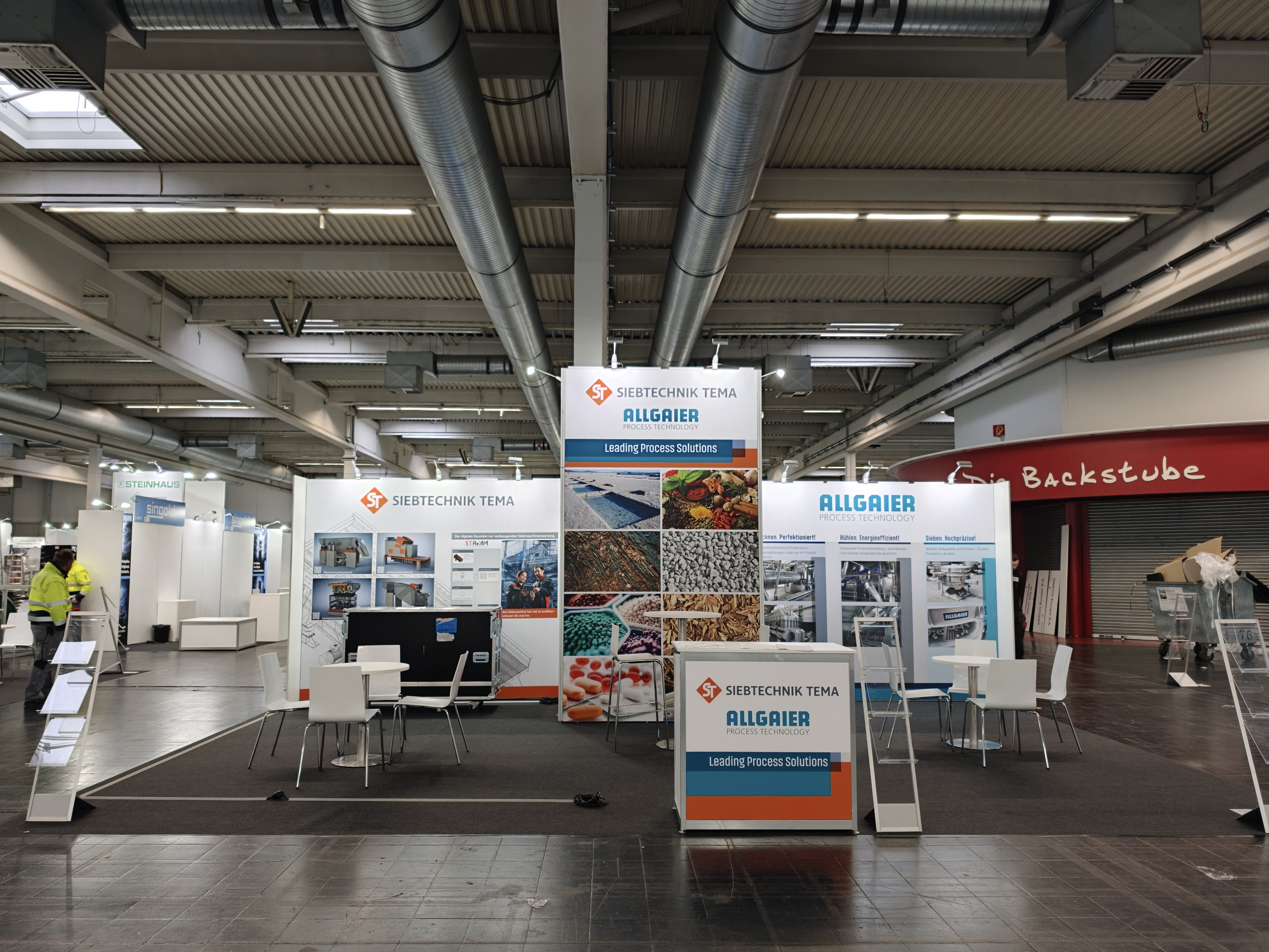 SIEBTECHNIK TEMA exhibition booth at SOLIDS Dortmund 2026, showing the Multiple-Deck-Sizer (MDS) and experts in conversation with visitors.